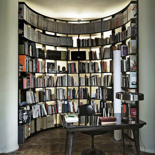 Ispirazione per uno studio minimal con libreria, pavimento in legno massello medio, scrivania autoportante, pavimento marrone e pareti bianche