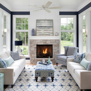 Beach style light wood floor sunroom photo in Minneapolis with a standard fireplace, a stone fireplace and a standard ceiling