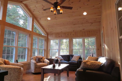 Example of a large classic medium tone wood floor sunroom design in Manchester with a standard ceiling