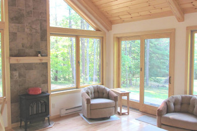 Example of a mid-sized classic light wood floor sunroom design in Boston with a wood stove, a tile fireplace and a standard ceiling