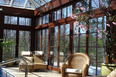 Foto di una veranda chic di medie dimensioni con pavimento in marmo, soffitto in vetro e pavimento marrone
