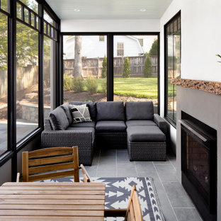 Example of a transitional gray floor sunroom design in DC Metro with a standard fireplace, a plaster fireplace and a standard ceiling