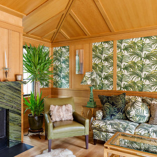 Esempio di una veranda tropicale di medie dimensioni con parquet chiaro, camino classico, cornice del camino in pietra e soffitto classico