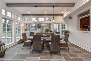 Example of a cottage slate floor dining room design in Chicago with a standard fireplace and a stone fireplace