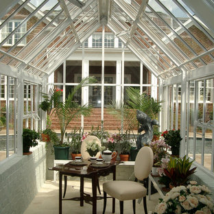 Small elegant travertine floor and beige floor sunroom photo in Charlotte with no fireplace and a glass ceiling