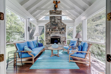 Inspiration for a coastal conservatory in DC Metro with a standard fireplace, a stone fireplace surround, a standard ceiling, white floors, dark hardwood flooring and a chimney breast.