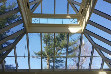 Example of a large trendy sunroom design in New York with a glass ceiling