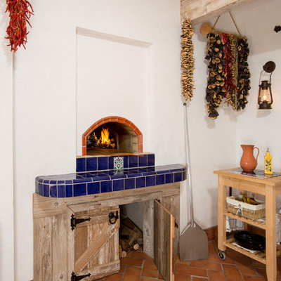 Tuscan terra-cotta tile and orange floor sunroom photo in DC Metro with a wood stove, a tile fireplace and a standard ceiling