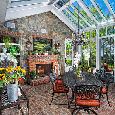 Elegant brick floor and red floor sunroom photo in Orange County with a brick fireplace and a glass ceiling
