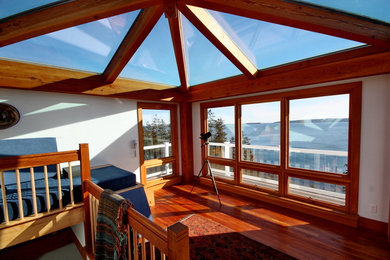 Idee per una grande veranda tradizionale con pavimento in legno massello medio, soffitto in vetro e nessun camino