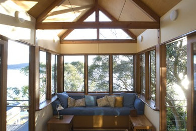 Cette image montre une véranda traditionnelle avec un sol en bois brun et un plafond standard.