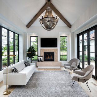 Photo of a mediterranean conservatory in Minneapolis with light hardwood flooring, a standard fireplace, a stone fireplace surround and a standard ceiling.