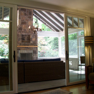 Sunroom - mid-sized contemporary medium tone wood floor and brown floor sunroom idea in Atlanta with a standard fireplace, a stone fireplace and a standard ceiling