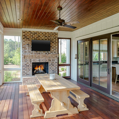 Inspiration for a mid-sized country dark wood floor and brown floor sunroom remodel in Atlanta with a standard fireplace, a brick fireplace and a standard ceiling