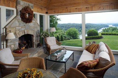 Large mountain style slate floor sunroom photo in Other with a standard fireplace, a stone fireplace and a standard ceiling