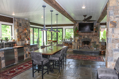 Bild på ett stort amerikanskt uterum, med kalkstensgolv, en standard öppen spis, en spiselkrans i sten och flerfärgat golv