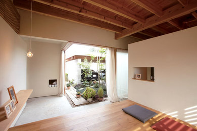 Foto de galería asiática grande sin chimenea con suelo de madera en tonos medios, techo estándar y suelo beige