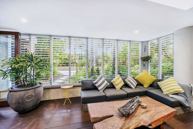 World-inspired conservatory in Cairns with dark hardwood flooring and a skylight.