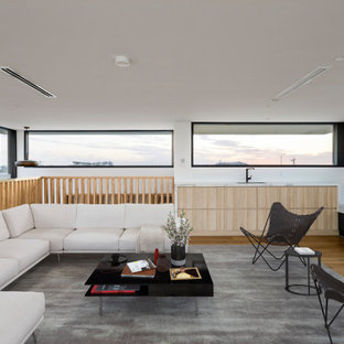 This is an example of a mid-sized contemporary sunroom in Melbourne with medium hardwood floors, a hanging fireplace, a metal fireplace surround and brown floor.