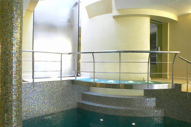 На фото: большой прямоугольный бассейн в доме в современном стиле с фонтаном и покрытием из плитки с