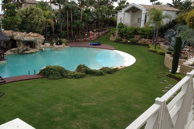 Photo of a medium sized mediterranean front custom shaped natural swimming pool in Other with a pool house.