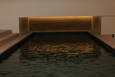 Идея дизайна: большой прямоугольный бассейн в доме в стиле модернизм