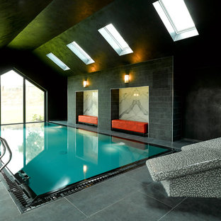 This is an example of a medium sized contemporary indoor rectangular swimming pool in Other with a pool house and tiled flooring.