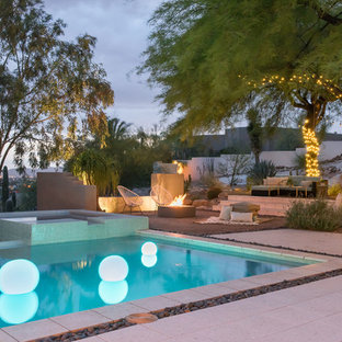 This is an example of a large contemporary backyard rectangular infinity pool in Phoenix with a hot tub and decomposed granite.