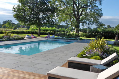 Contemporary swimming pool in London with stamped concrete.