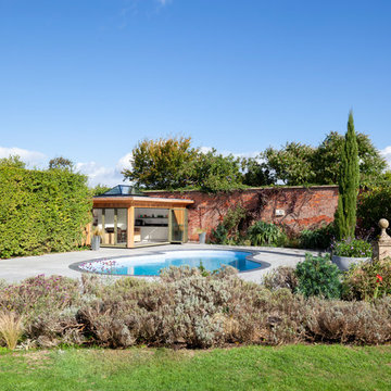 Contemporary pool house amongst a traditional setting.