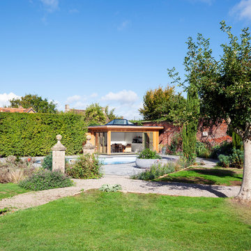 Contemporary pool house amongst a traditional setting.