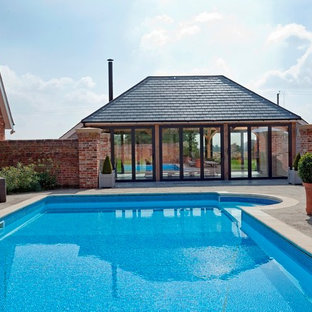 Photo of a rural rectangular lengths swimming pool in Other with concrete paving.