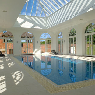This is an example of a medium sized classic indoor rectangular lengths swimming pool in Other with a pool house and tiled flooring.