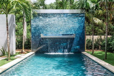 Idée de décoration pour une piscine arrière design rectangle avec un point d'eau.