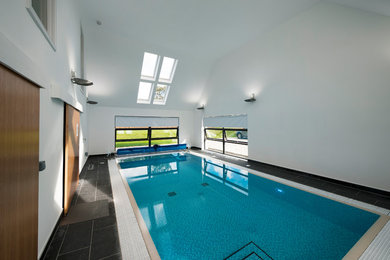 Источник вдохновения для домашнего уюта: большой спортивный, прямоугольный бассейн в доме в стиле модернизм с покрытием из плитки