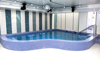 Photo of a small contemporary indoor custom shaped swimming pool in London.