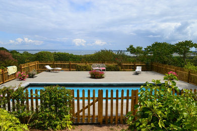 Medium sized vintage rectangular swimming pool in Other with decking.