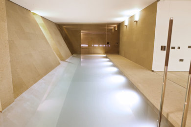 Photo of a medium sized contemporary indoor rectangular swimming pool in London with a water feature.