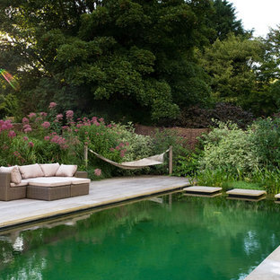 Klassischer Schwimmteich hinter dem Haus in rechteckiger Form mit Dielen in Sussex