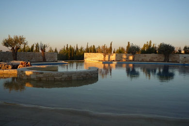 Aménagement d'une grande piscine hors-sol et arrière sur mesure avec un bain bouillonnant et des pavés en pierre naturelle.