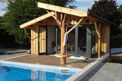 Photo of a contemporary back rectangular swimming pool in Other with a pool house and tiled flooring.