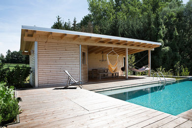 Foto de casa de la piscina y piscina actual rectangular con entablado