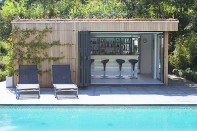 Contemporary swimming pool in Dorset with a bar area.