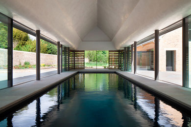 Back rectangular lengths swimming pool in Sussex with a pool house.