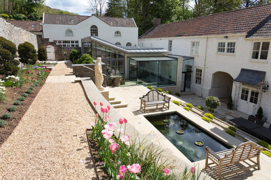 This is an example of a contemporary back rectangular swimming pool in Other with a pool house and natural stone paving.