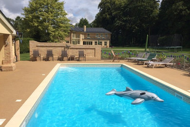 Mittelgroßer Klassischer Pool hinter dem Haus in rechteckiger Form mit Natursteinplatten in Wiltshire
