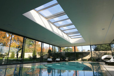 Inspiration for a large contemporary swimming pool in London with a pool house.