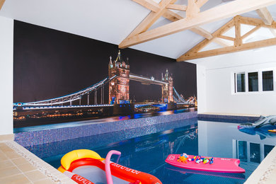 На фото: спортивный, прямоугольный бассейн в доме в современном стиле с покрытием из плитки с