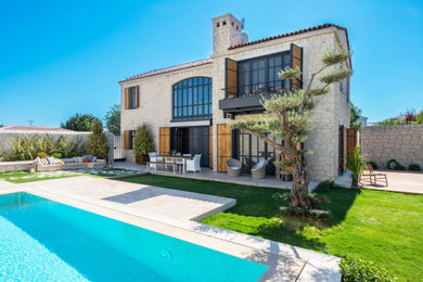 Diseño de piscina natural mediterránea extra grande rectangular en patio delantero con paisajismo de piscina y adoquines de piedra natural