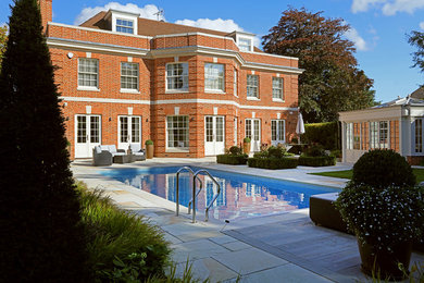 Design ideas for a large classic back rectangular swimming pool in Surrey with tiled flooring.
